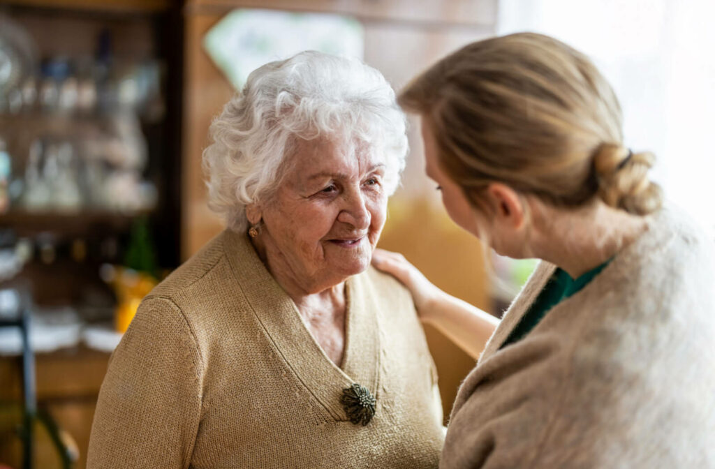 A caregiver talking to a senior woman with dementia in a senior living community
